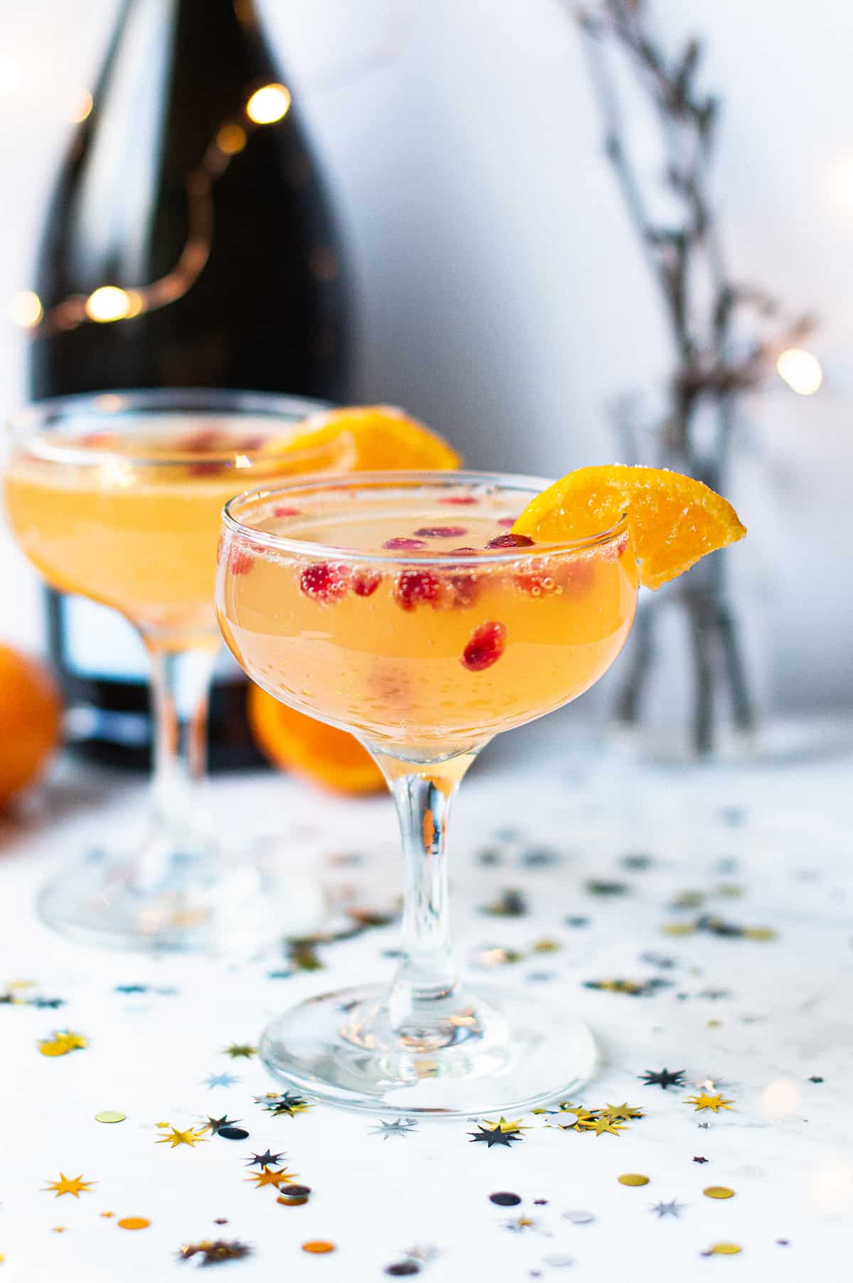 2 clementine champagne cocktails with orange garnish & confetti