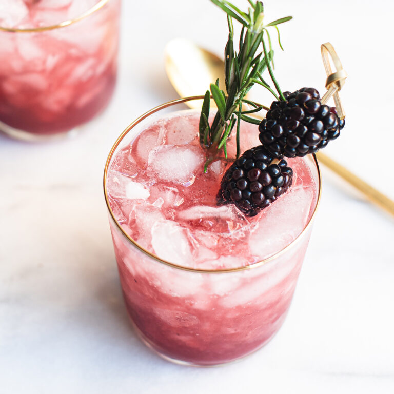 blackberry smash cocktail garnished with blackberries and rosemary