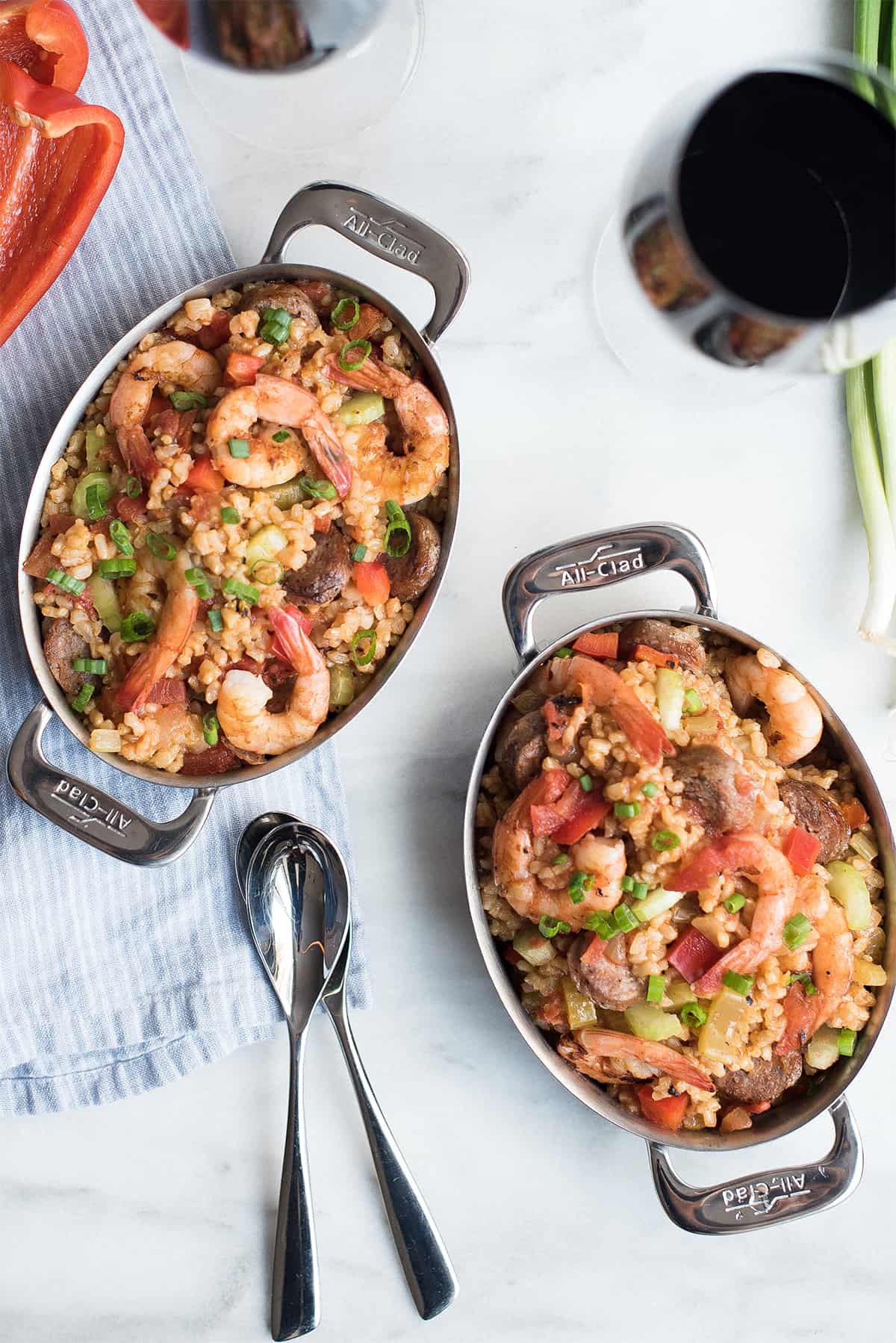 two pans of creole style shrimp jambalaya with spoons