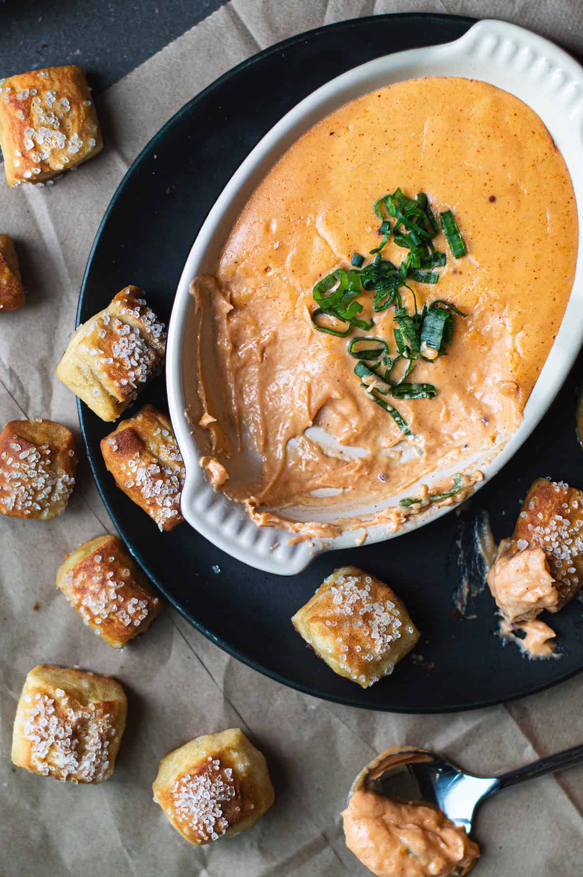 pretzel bites on plate with bowl of beer cheese dip + green plaid napkin