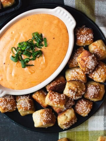 pretzel bites with plate of beer cheese on checked napkin