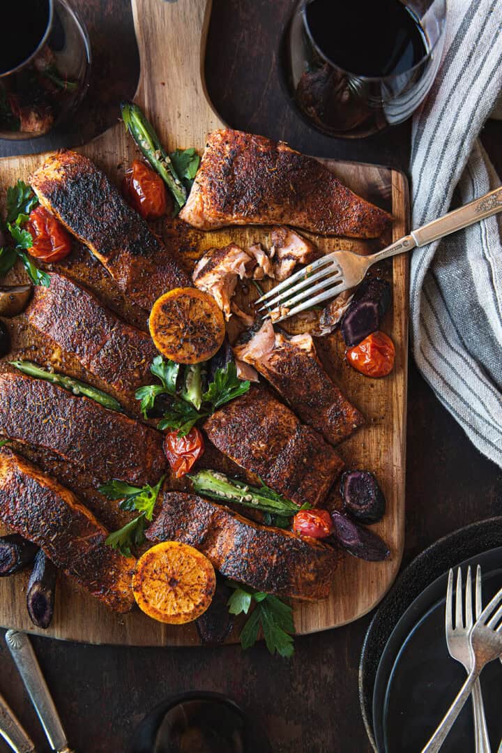 blackened salmon filets, served on wood board with fork & linen napkin