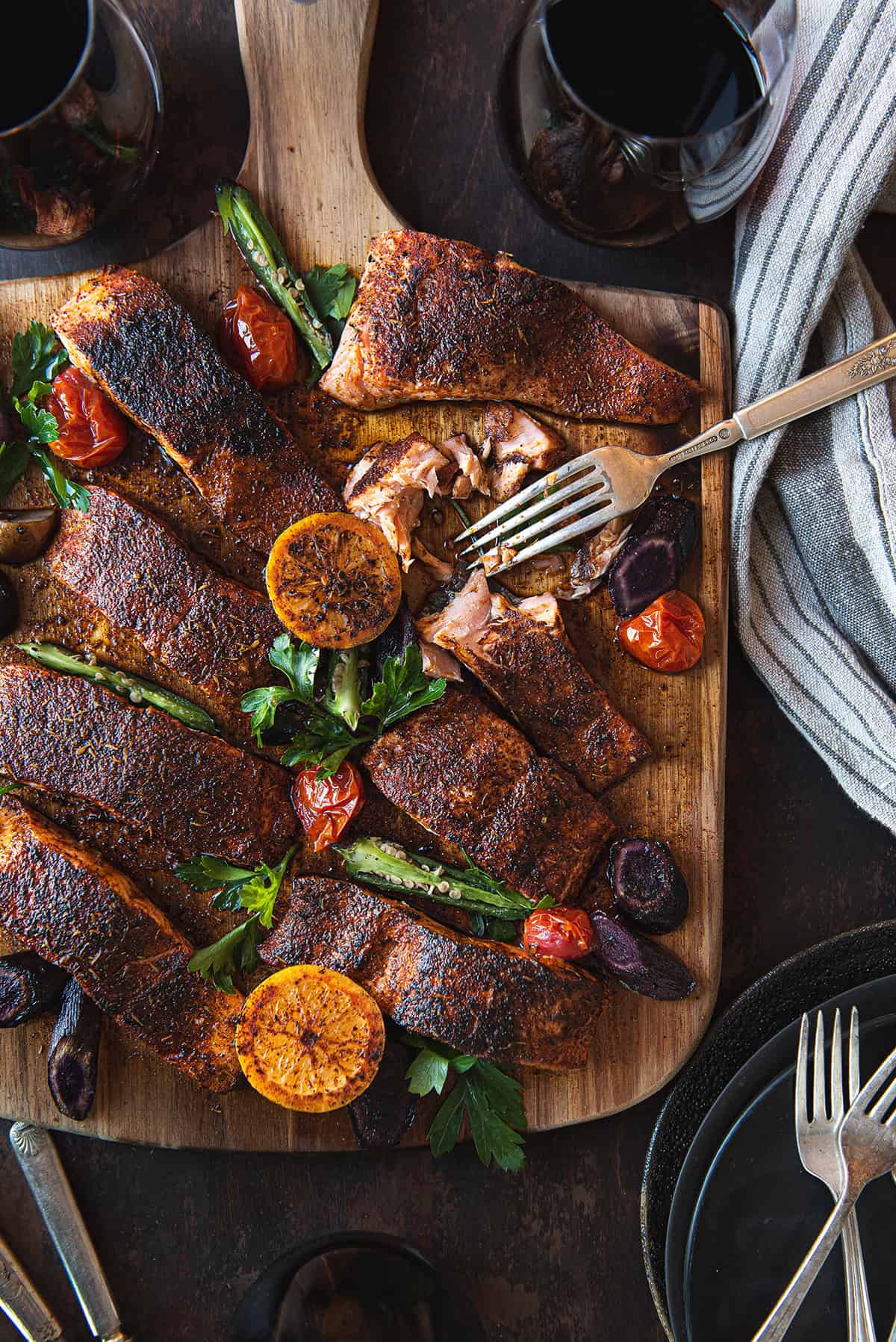 blackened salmon filets, served on wood board with fork & linen napkin