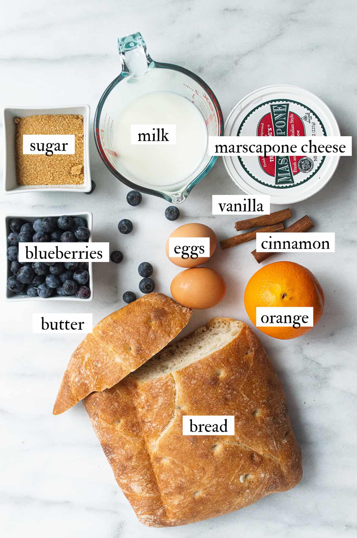 ingredients for Italian bread pudding scattered on white table