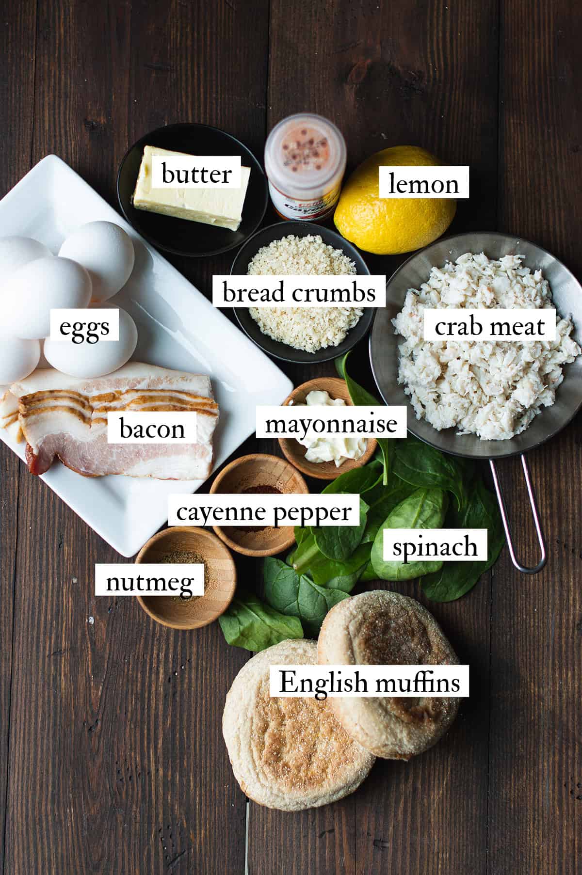 Ingredients for Crab Cake Benedict laid out on a wooden table