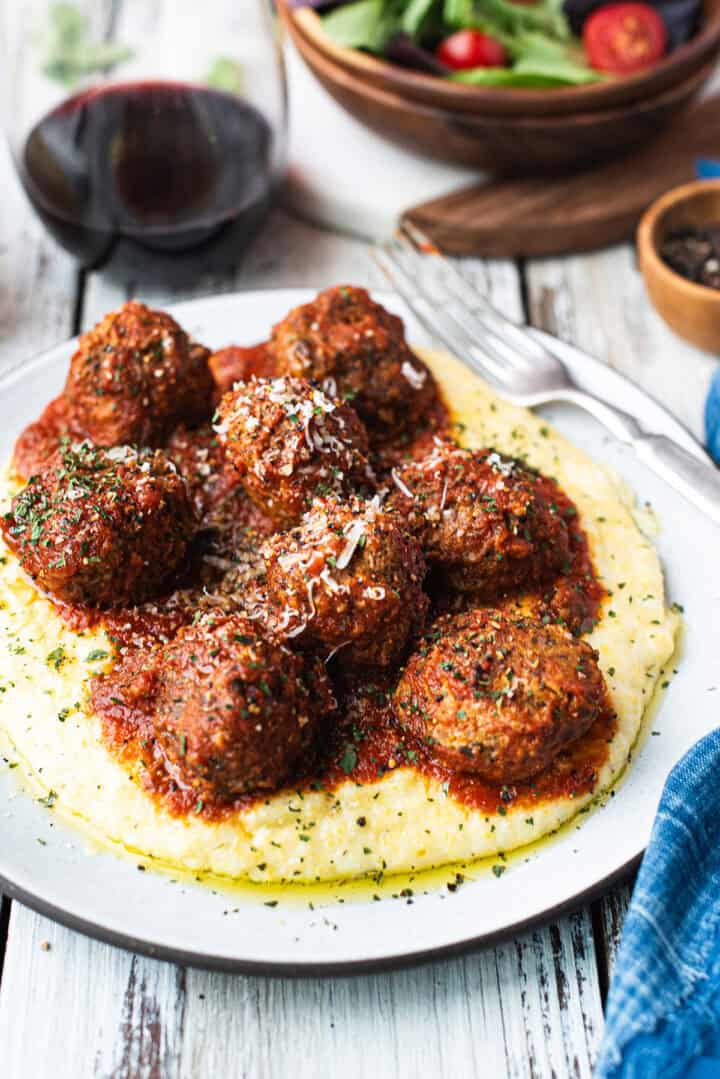 juicy homemade meatballs with tomato sauce over polenta