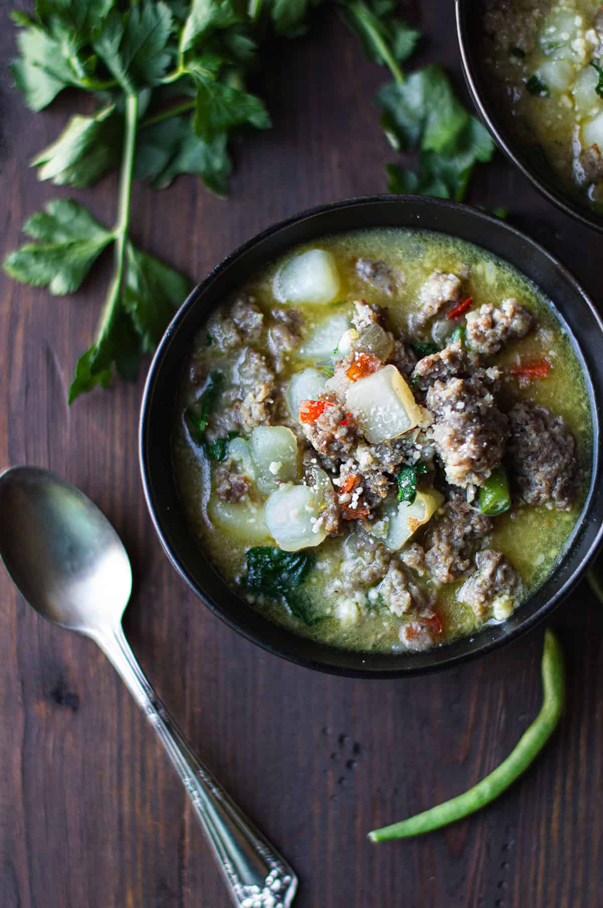 Hearty sausage potato soup topped with fresh herbs