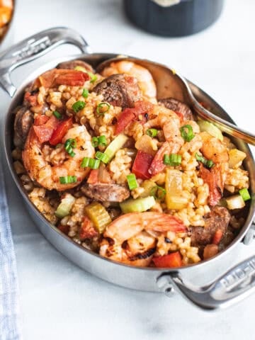 serving pan of shrimp jambalaya with bottle of wine