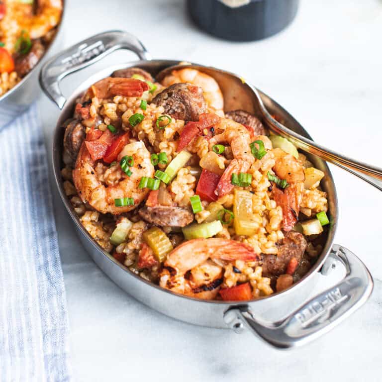 serving pan of shrimp jambalaya with bottle of wine