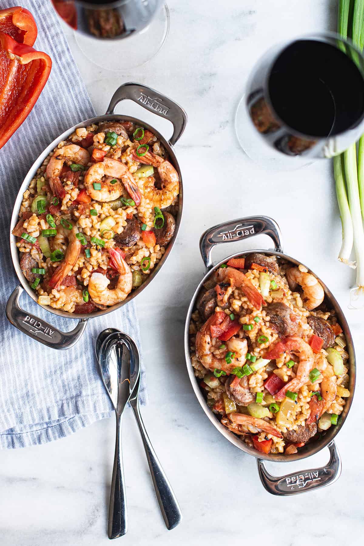 two pans of creole style shrimp jambalaya with spoons