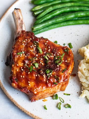 Korean glazed pork chop on plate with green beans and mashed potatoes