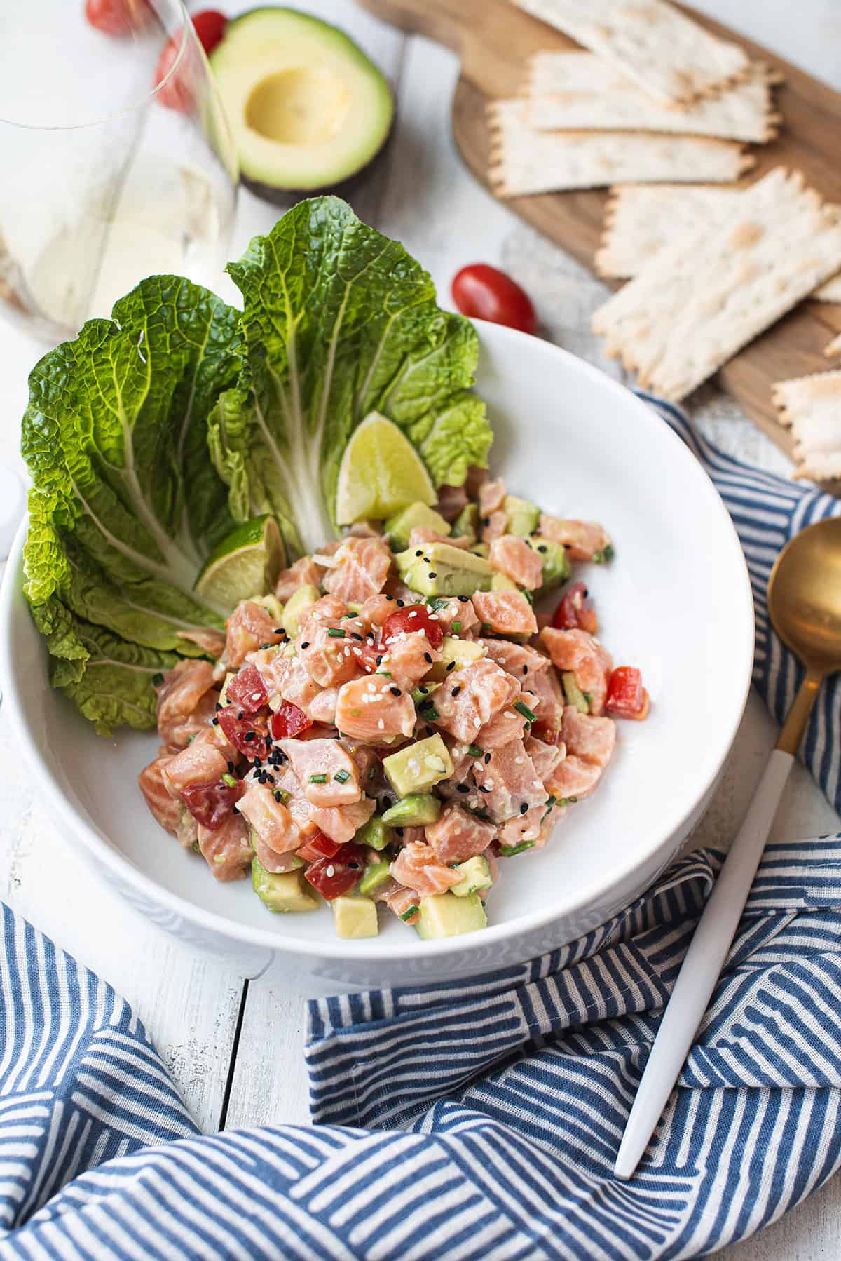 salmon ceviche in white bowl with lettuce leaf garnish