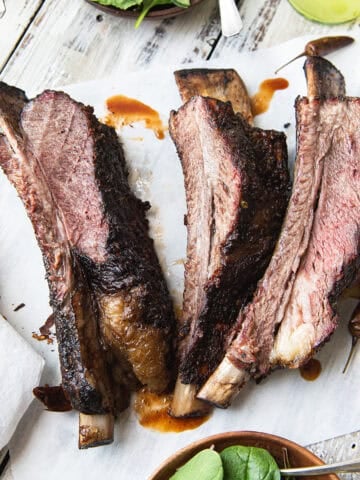 smoked beef ribs on parchment paper with sauce