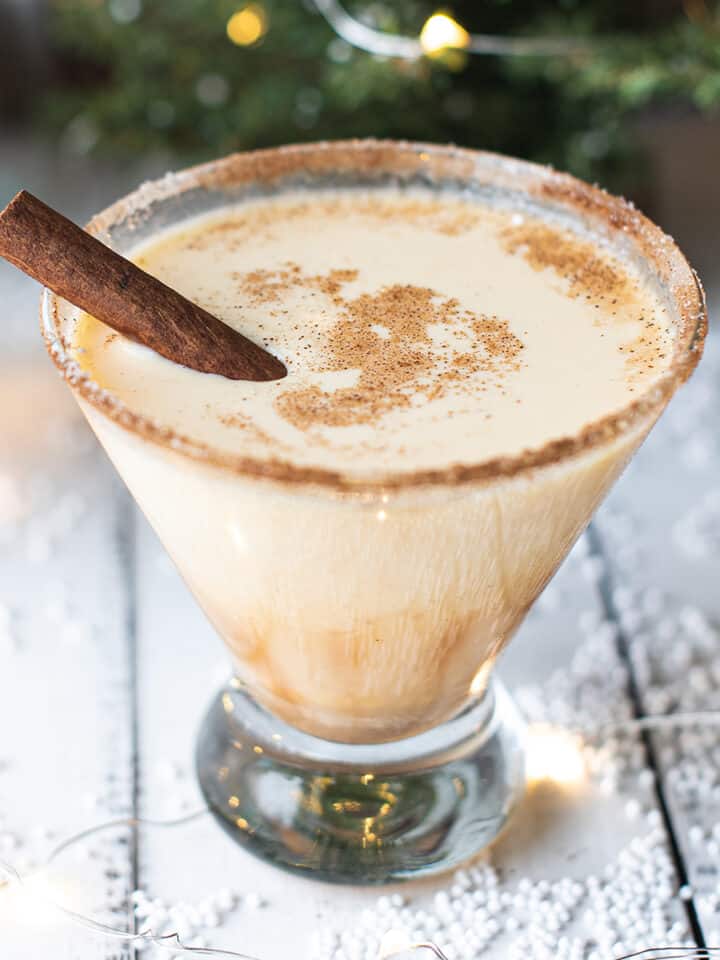 spiked eggnog in cocktail glass, garnished with cinnamon sitick