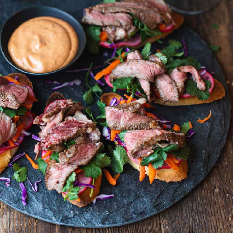A plate of steak crostini dipping sauce