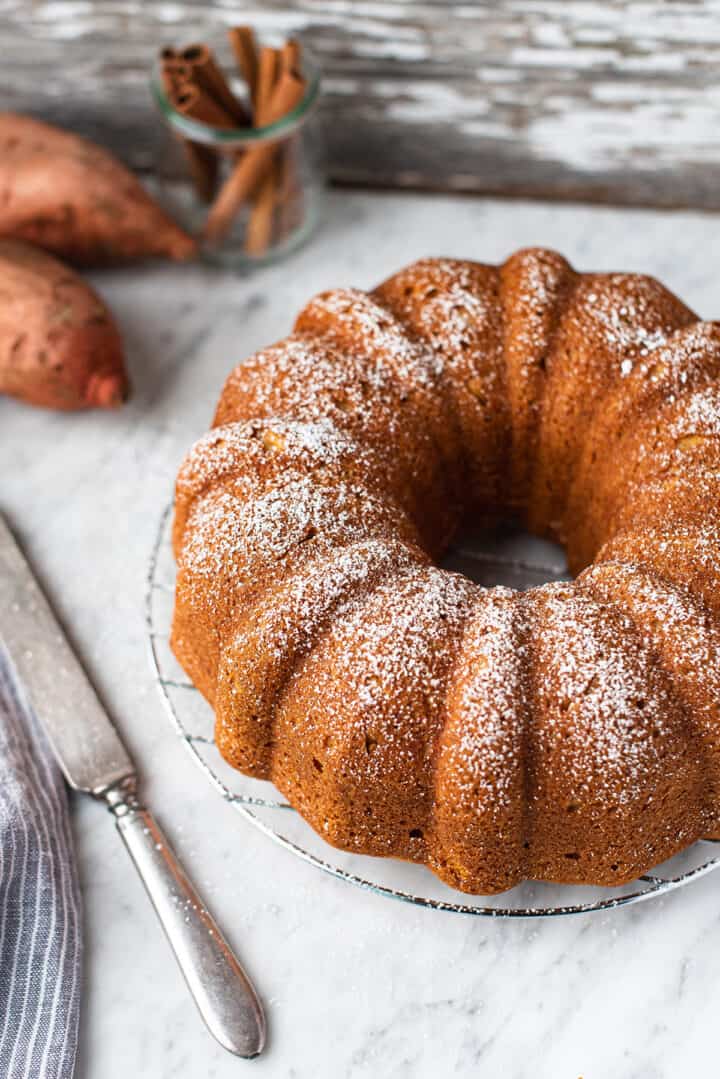 sweet potato poundcake made with bundt pan, sprinkled with powdered sugar on marble counter