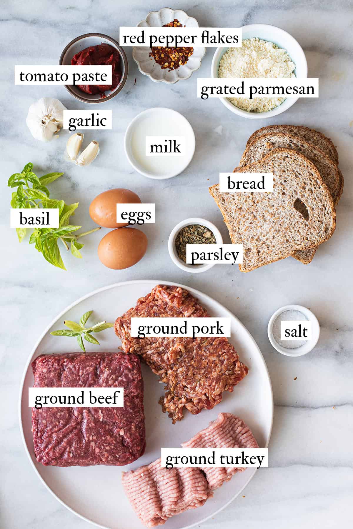 ingredients for homemade meatballs spread on white countertop