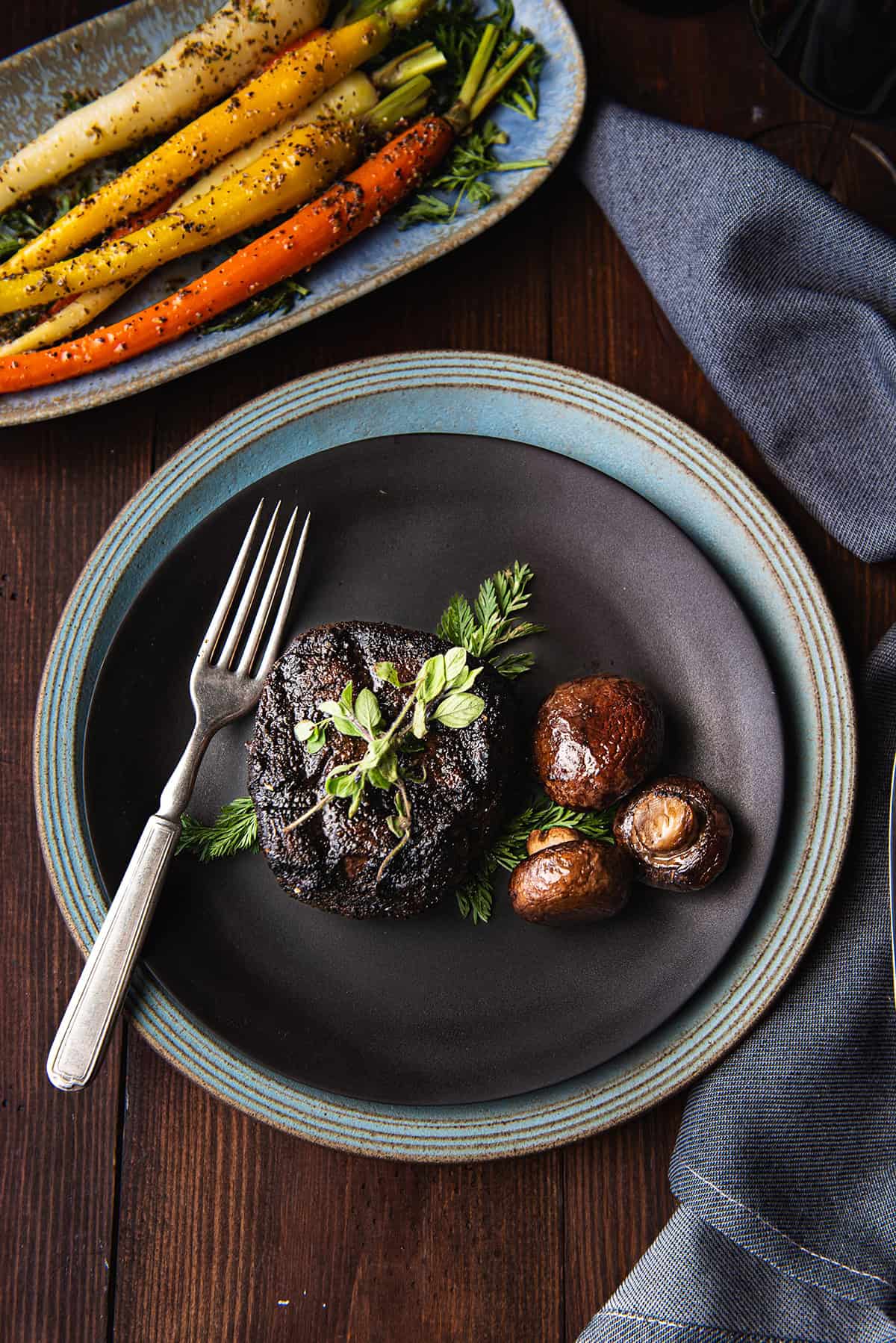 coffee rubbed filet mignon on black plate with fork