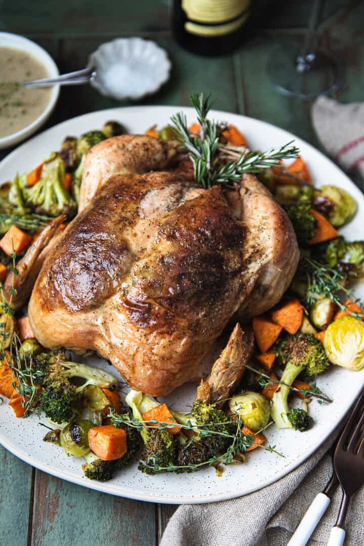 whole roasted chicken served on plate with vegetables