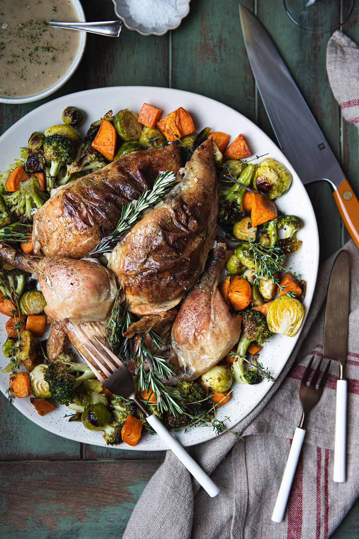 crispy skin roasted chicken, sliced an served on plate with vegetables