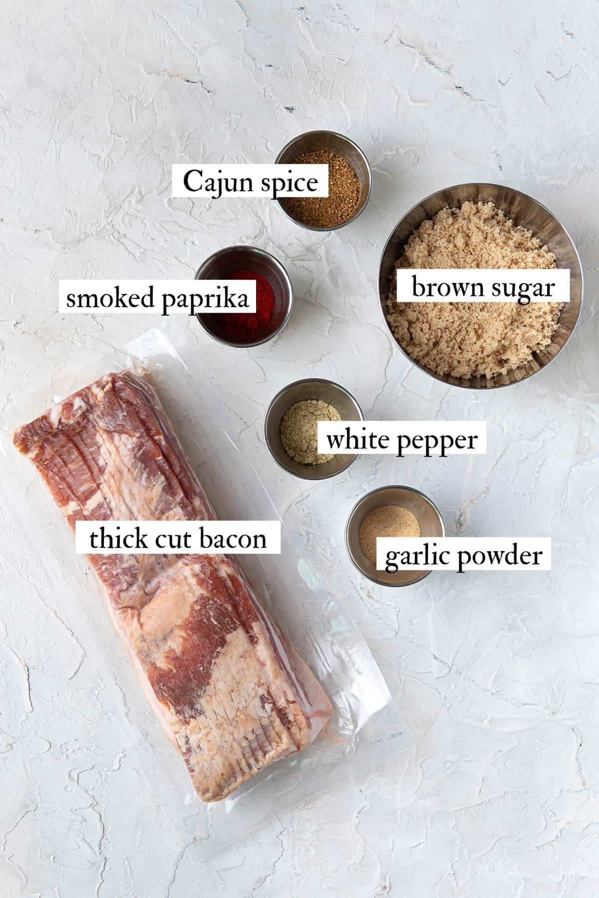 ingredients for candied bacon including thick cut bacon, brown sugar and Cajun spice blend